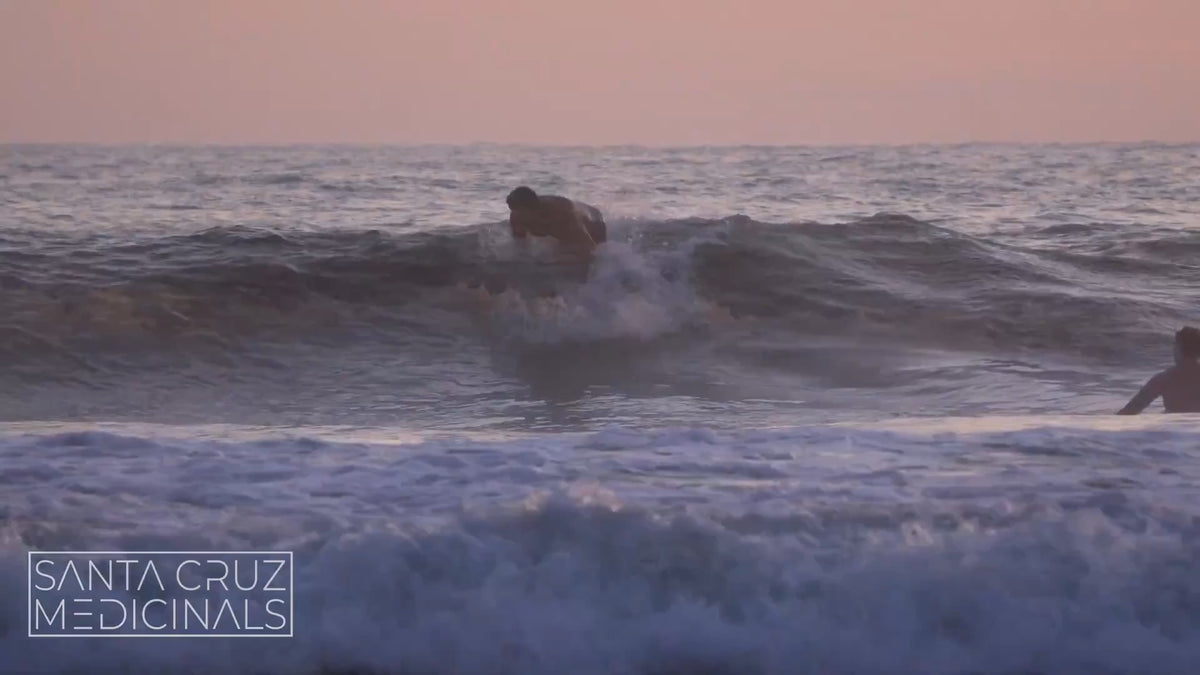 A surfer catching a wave off Santa Cruz at dusk