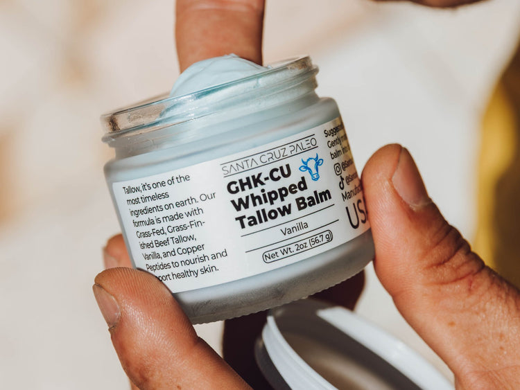 Hands holding an open jar of Santa Cruz Paleo GHK-Cu Whipped Tallow Balm