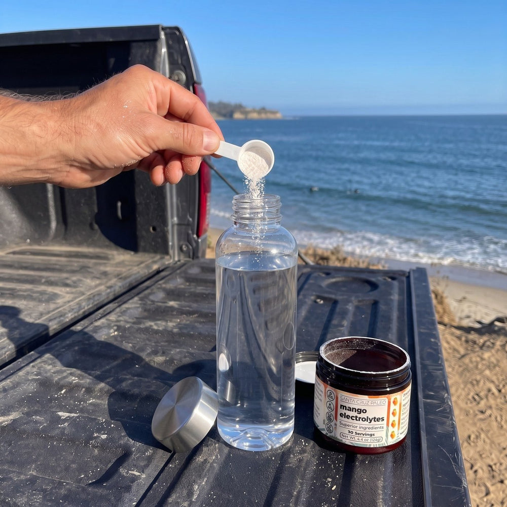 Pouring a scoop of electrolytes into a water bottle by the sea